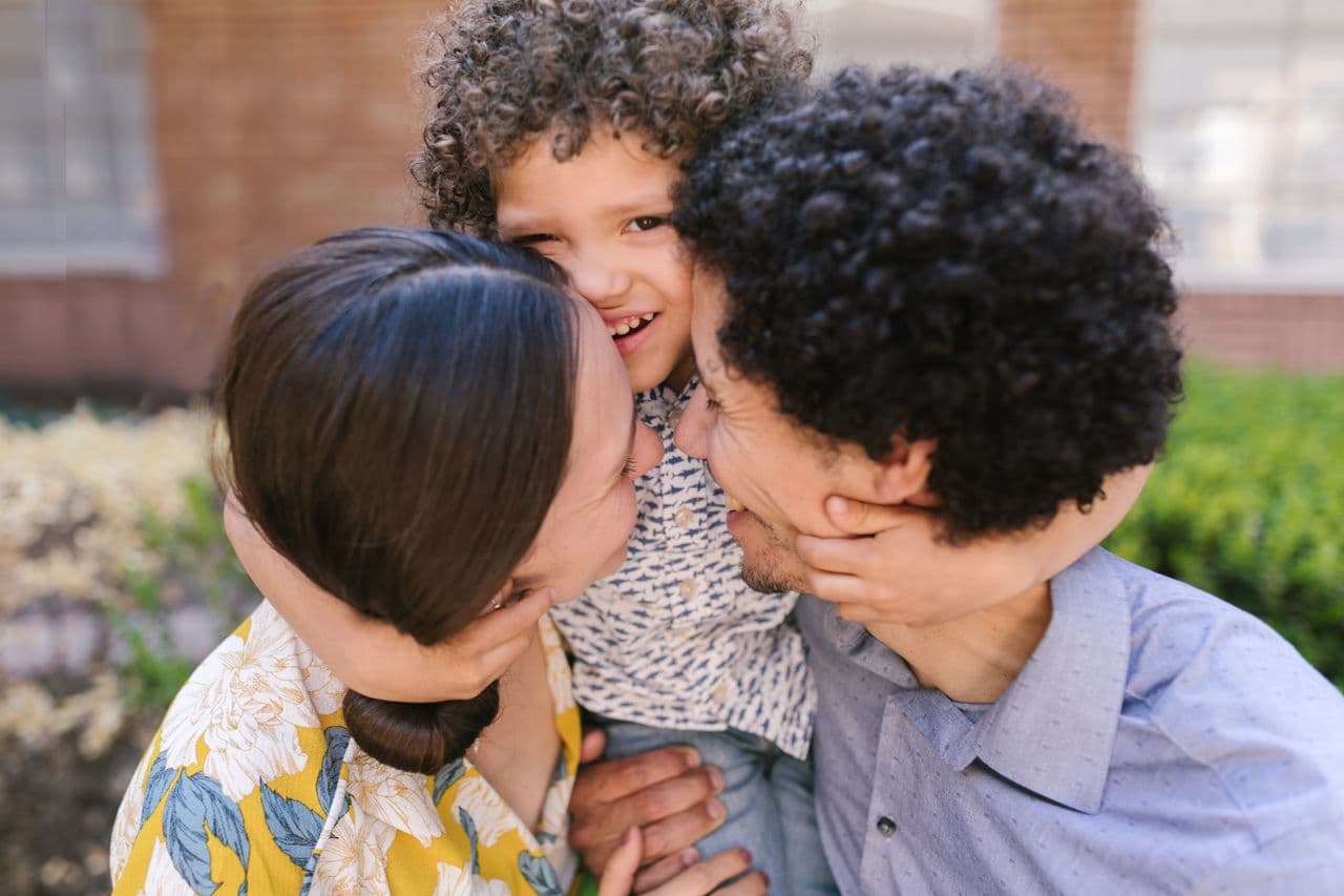 Familia joven abrazando a su hijo